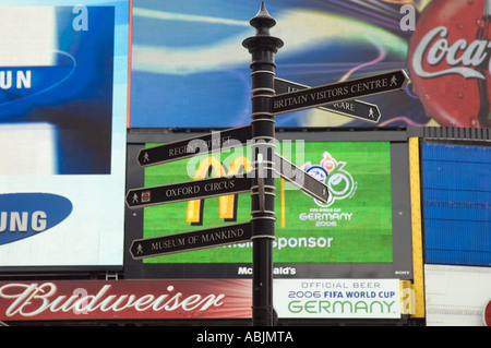 Touristischer Wegweiser vor Hintergrund der Neon Werbung in Piccadilly Circus London, England Stockfoto