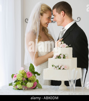 Braut und Bräutigam neben Kuchen Stockfoto