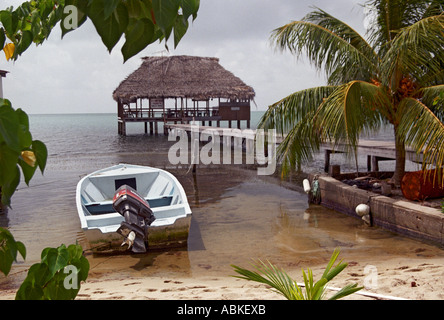 Placencia Stan Creek Belize Mittelamerika. Bar auf Stelzen im Meer vor Placencia Strand mit festgemachten Boot vor Stockfoto