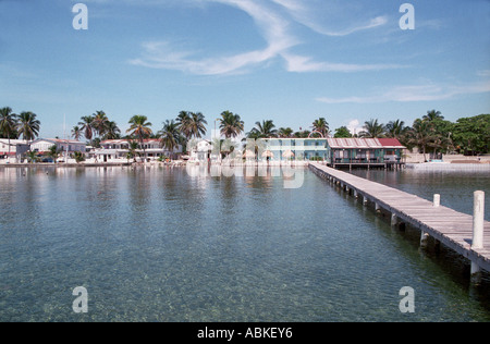 Caye Caulker Belize Mittelamerika. Holzsteg führt zum Hotel und anderen Gebäuden am Meer vom Meer Stockfoto