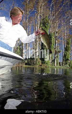 Foto der mittleren gealterten aufgeregt Fischer hält seinen Fang großer Bass auf großen Zentral-Florida-See Stockfoto