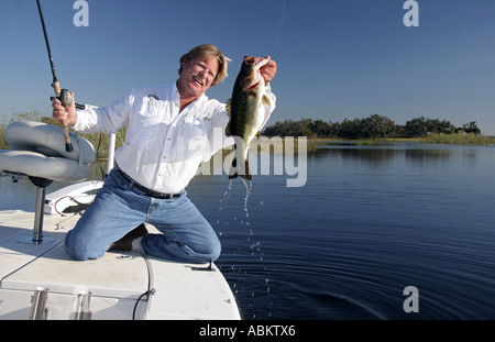 Foto der mittleren gealterten aufgeregt Fischer hält seinen Fang großer Bass auf großen Zentral-Florida-See Stockfoto