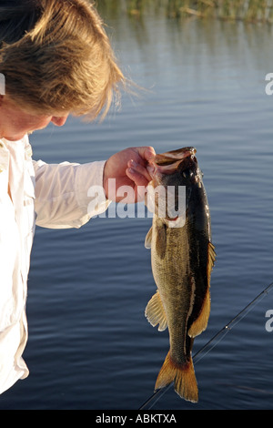 Foto der mittleren gealterten aufgeregt Fischer hält seinen Fang großer Bass auf großen Zentral-Florida-See Stockfoto