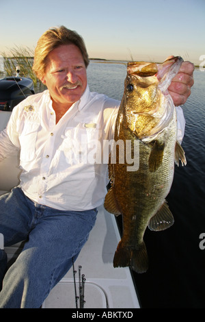 Foto der mittleren gealterten aufgeregt Fischer hält seinen Fang großer Bass auf großen Zentral-Florida-See Stockfoto