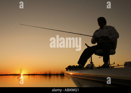 Foto der Mann mittleren Alters, Angeln vom Boot auf den Sonnenaufgang am großen See in Zentral-Florida Stockfoto