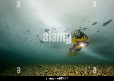 Taucher in einem zugefrorenen See Stockfoto