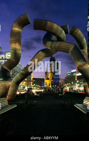 Kaiser Wilhelm Gedachtniskirche in der Abenddämmerung, umrahmt von einer modernen Skulptur, Berlin, Deutschland. Stockfoto