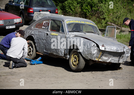 Fahrer, die ein Auto vor der nächsten Hitze von Folkrace eine Art Banger racing bei Torslanda Rennbahn Göteborg Schweden ausbessern Stockfoto