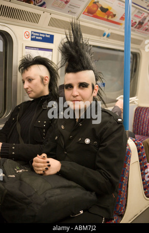 Goth Girl mit Irokesenschnitt Frisur auf London Tube mit Freund Stockfoto