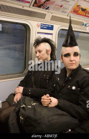 Goth-Mädchen mit überraschenden Mohikaner Frisur auf London Tube mit Freund Stockfoto