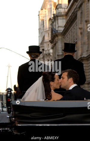 Braut und Bräutigam fahren Sie Whitehall in einer Pferdekutsche nach ihrer Hochzeit am St. Pauls Church, Covent Garden, London Stockfoto