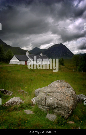 vertikale Portraitfoto von schwarzen Felsen Croft Ferienhaus auf Rannoch moor in Schottland mit Buchaille Etive Mor Mountain in die Hinterg Stockfoto