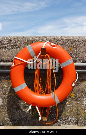 Orange Rettungsring auf Hafenmauer Stockfoto