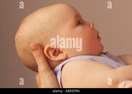 Profil von Baby von Mutter gehalten Stockfoto