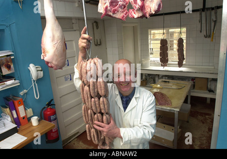 Metzger enthält eine Zeichenfolge von Würsten hängen von einem Haken in seinem Shop UK Stockfoto