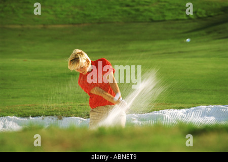 Frau Golfer Strahlen schoss aus Sandfang oder bunker Stockfoto