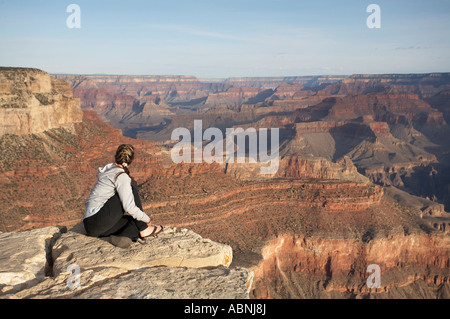 Frau auf Felsen sitzend, mit Blick auf Grand Canyon, Arizona, USA Stockfoto