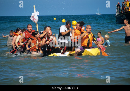 BENLLECH ISLE OF ANGLESEY UK August männliche und weibliche Konkurrenz in jährlichen Floß Rennen quer durch die Bucht, die Ziellinie zu erreichen Stockfoto