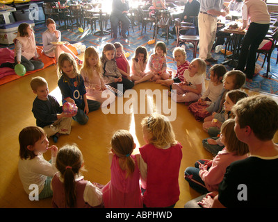 Kinder sitzen im Kreis spielen passieren das Paket Spiel bei kleinen Kindern Party für sechs bis sieben-jährige, UK Stockfoto