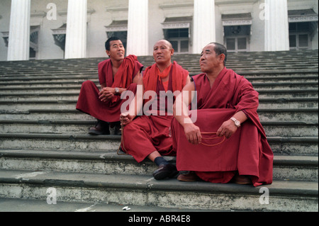 Drei tibetische Mönche sitzen auf den Stufen des asiatischen Bibliothek Mumbai Indien Stockfoto