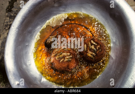 Bahia, Brasilien. Sauber geschlagene Aluminium Schale mit Acaraje Bohne Mehl Bratlinge Braten mit Garnelen eingebettet in den Wipfeln. Stockfoto