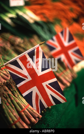 Union Jack-Flaggen unter Spargel, Lauch und Karotten auf dem Display an Borough Market, Southwark, London, England Stockfoto