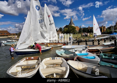 Segeln auf dem Zettel am Bosham West Sussex England UK Kirche der Heiligen Dreifaltigkeit im Hintergrund gestartet wird dinghys Stockfoto