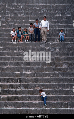 Guatemaltekischen Familie mit Kindern in Hülle und Fülle auf den Stufen zum Gipfel der alten Maya-Tempel II Tikal El Petén Guatemalas Stockfoto