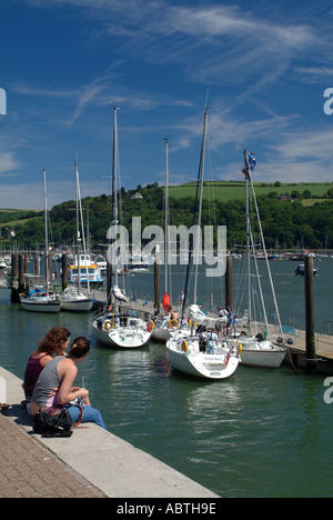 Zwei Mädchen sitzen am Ufer genießen Sonne in Dartmouth Devon Stockfoto