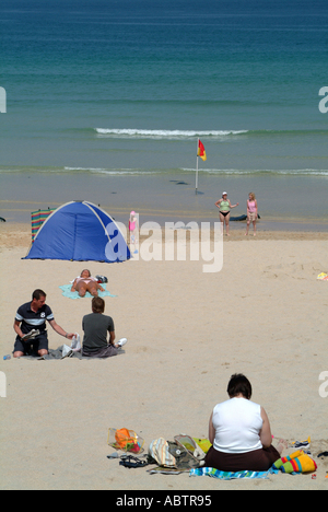 Menschen, die zum Sonnenbaden am Strand von St Ives Cornwall Stockfoto