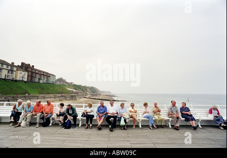 Besucher nach Cromer Norfolk UK sitzen auf einer Bank am pier Stockfoto