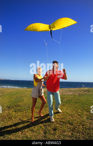 Romantisch zu zweit zu genießen, an einem schönen sonnigen Tag am Meer ein Lenkdrachen fliegen Stockfoto