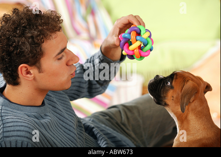 Mann spielt mit Boxer Hund - Welpe Stockfoto