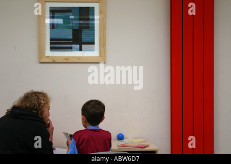 Ein Freiwilliger nimmt eine Lesung Lektion bei Betty Layward Primary School, London, UK. Stockfoto