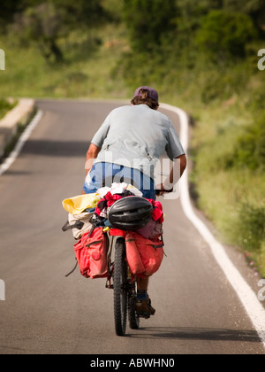 Ein Radfahrer auf der Landstraße in den "Parque natural de Los Alcornocales". Stockfoto