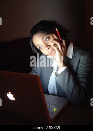 Business-Frau von Hispanic Ethnicity Anzug grau grau Business mit einem Apple-Macintosh-Computer Stockfoto