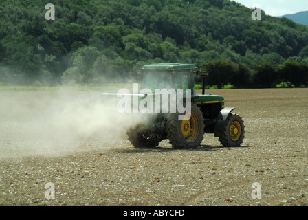 Landwirt treibende John Deere Traktor mit Streuer Anlage Verbreitung staubigen landwirtschaftliche Kalk auf Feld-Hof in der Nähe von Machynlleth Powys in Wales Großbritannien Landwirtschaft Stockfoto