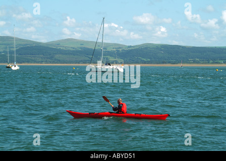 Blick vom Aberdyfi oder Aberdovey Strand des Menschen im Leben Jackenpaddeln im roten Kajak in der malerischen Flussmündung Dyfi River Dovey Gwyned North Wales Großbritannien Stockfoto