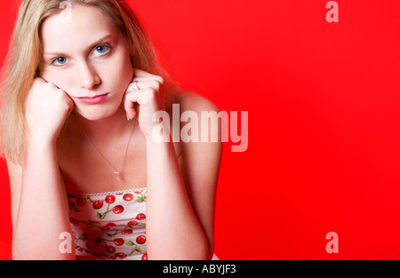 Eine junge Frau lehnt sich auf ihre Ellbogen und Stuppern und blickt mit einem verspielten Ausdruck in die Kamera. USA. Stockfoto