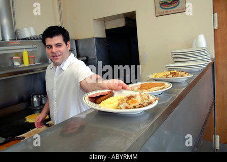 Kurzer Koch bereitet Essen in einem kleinen restaurant Stockfoto