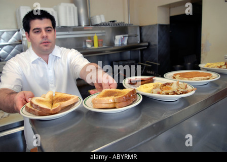 Kurzer Koch bereitet Essen in einem kleinen restaurant Stockfoto