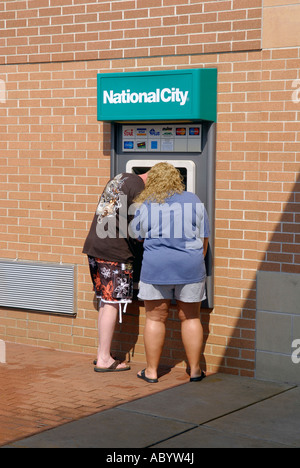 Mann und Frau zeichnen Sie Bargeld von einem Geldautomaten einer Bank Stockfoto