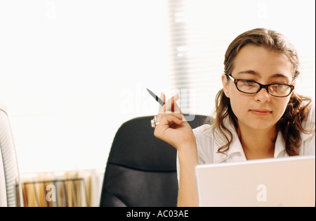 junge Geschäftsfrau sitzen am Schreibtisch im Büro arbeiten am Laptop-computer Stockfoto