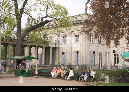 Touristen sitzen durch den Palast auf dem Wasser in Royal Lazienki Park in Warschau, Polen Stockfoto