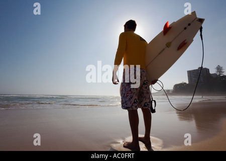 Eine Surfer schaut auf die Wellen am Manly Beach an der Nordküste Sydneys Stockfoto