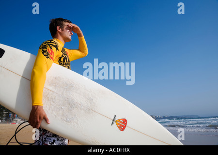 Eine Surfer schaut auf die Wellen am Manly Beach an der Nordküste von Sydney s Stockfoto