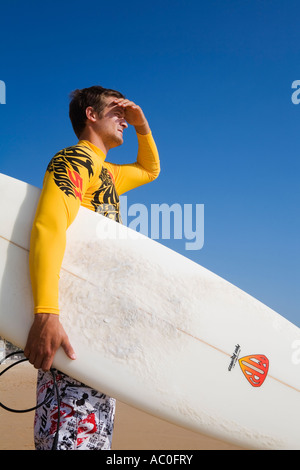 Eine Surfer schaut auf die Wellen am Manly Beach an der Nordküste von Sydney s Stockfoto