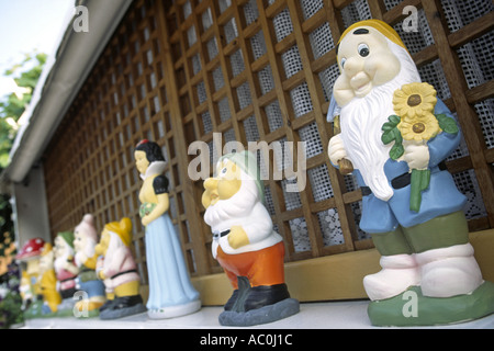 Kleine Statuen von Schneewittchen und die sieben Zwerge säumen den Rand der Wand eines Hauses in Grado, Italien. Stockfoto