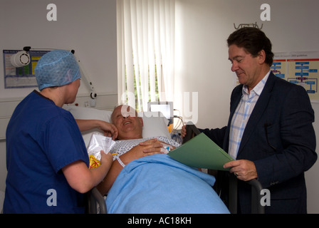 Patienten im Aufwachraum nach Operation an einem Tag Chirurgie, Cobham, Surrey, UK von Krankenschwester und GP überwacht wird. Stockfoto