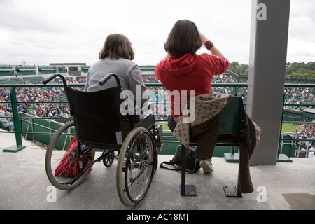 Frau-Rollstuhlfahrer und Begleiter bei Wimbledon Tennis Championship. VEREINIGTES KÖNIGREICH. Stockfoto